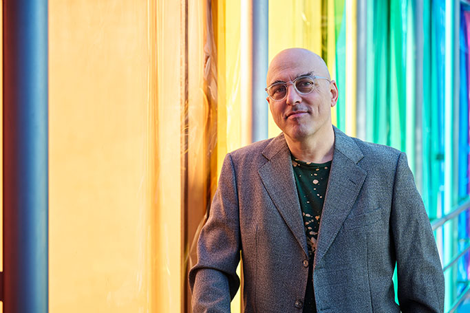 Künstlerportrait des Musikers und Labelgründers Matthias Götz vor einem Fenster mit bunten transparenten Folien.