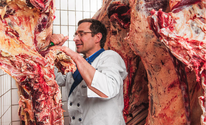 Der Metzger Oliver Lutz arbeitet in seinem Kühlraum an Rinderhälften, Peolplefotografie ©  Florian Freund